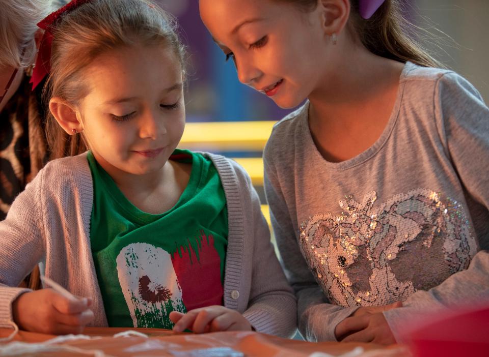 Emma Pluckebaum (left), 5, and her sister Elin Pluckebaum, Kokomo, make metal stamp art at Fiesta Familia, which translates to a party for families, at Indianapolis Children's Museum, Indianapolis, Sunday, Sept. 23, 2018. The one-day event is in Hispanic Heritage Month, and brings a taste of Latino activities and culture to the museum. 