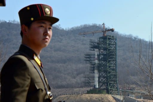 A soldier stands guard in front of the Unha-3 rocket at North Korea's Tangachai-ri space center in April. North Korea has installed the first stage of a long-range rocket it plans to launch this month in position, a report said Monday