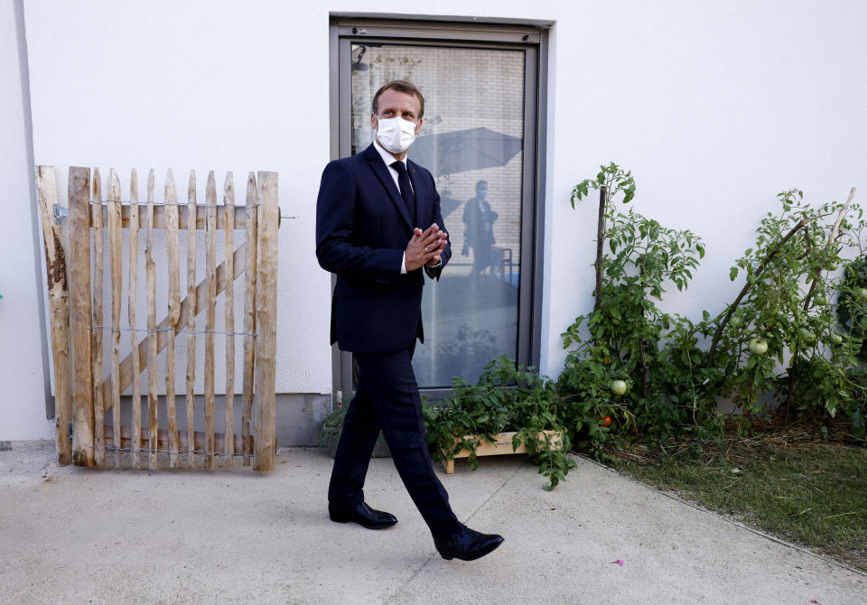 French President Emmanuel Macron greets residents as he arrives at the 'La Bonne Eure' nursing home in Bracieux, central France, Tuesday, Sept. 22, 2020. For the first time in months, virus infections and deaths in French nursing homes are on the rise again. (Yoan Valat/Pool Photo via AP)