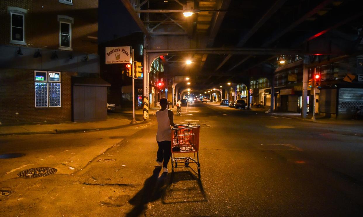 <span>A man pulling a shopping cart walks along Kensington Ave in Philadelphia, 2017. ‘There are over 150 channels dedicated to Kensington and all the things that take place here,’ a harm reduction professional says.</span><span>Photograph: The Washington Post/Getty Images</span>