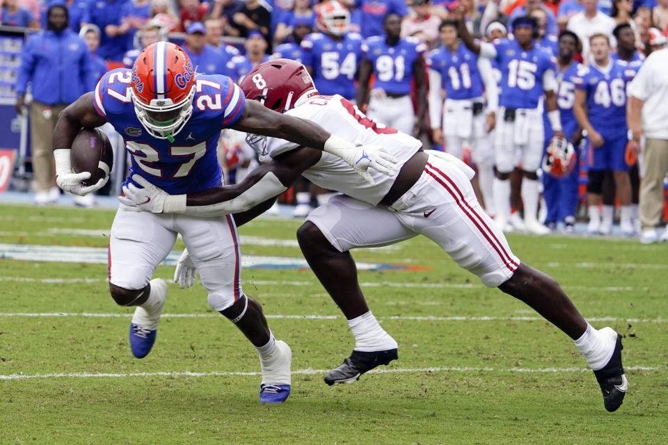 Florida running back Dameon Pierce (27) tries to break a tackle by Alabama linebacker Christian Harris (8) during the first half of an NCAA college football game, Saturday, Sept. 18, 2021, in Gainesville, Fla. (AP Photo/John Raoux)