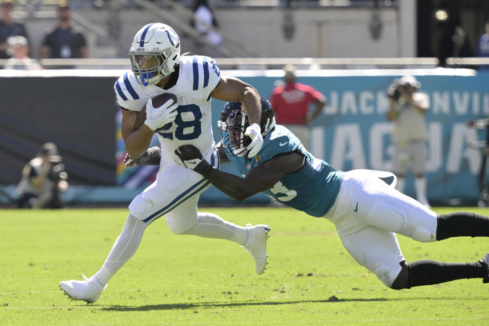 Indianapolis Colts running back Jonathan Taylor (28) is tackled by Jacksonville Jaguars linebacker Foyesade Oluokun (23) during the first half of an NFL football game, Sunday, Oct. 15, 2023, in Jacksonville, Fla. (AP Photo/Phelan M. Ebenhack)