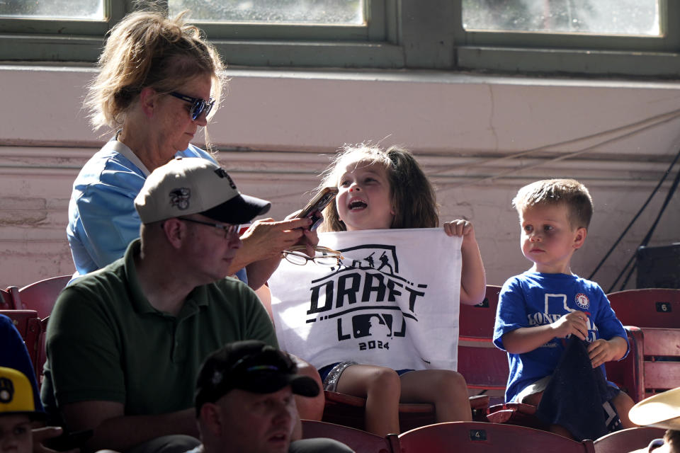 Fans look on during the MLB baseball draft at the Cowtown Coliseum in Fort Worth, Texas, Sunday, July 14, 2024. (AP Photo/LM Otero)