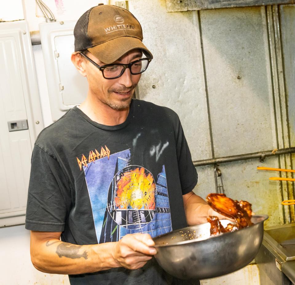 Black Sheep on Broadway line cook Jeremy Holets tosses up some wings with sheep sauce, which is a bacon bourbon marmalade, on July 18.