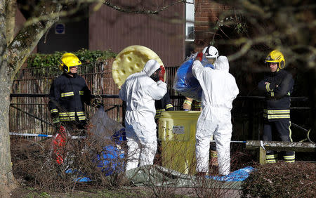 Officials pack away the protective suits after colleagues used them whilst repositioning the forensic tent, covering the bench where Sergei Skripal and his daughter Yulia were found, in the centre of Salisbury, Britain, March 8, 2018. REUTERS/Peter Nicholls