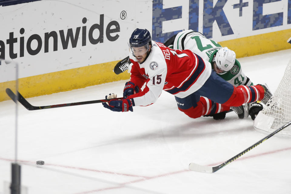 Columbus Blue Jackets' Michael Del Zotto, left, dives after a puck against Dallas Stars' Alexander Radulov during the second period of an NHL hockey game Tuesday, Feb. 2, 2021, in Columbus, Ohio. (AP Photo/Jay LaPrete)