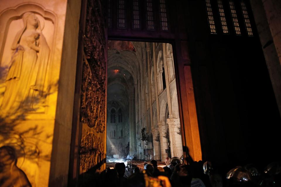 This general view from the entrance shows smoke rising in front of the altar cross at Notre-Dame Cathedral in Paris on April 15, 2019, after a fire engulfed the building. (Photo: Philippe Wojazer/AFP/Pool/Getty Images) 