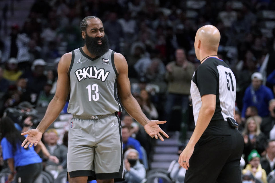 Brooklyn Nets guard James Harden talks to referee Aaron Smith during the first half of the team's NBA basketball game against the Dallas Mavericks in Dallas, Tuesday, Dec. 7, 2021. (AP Photo/Tony Gutierrez)