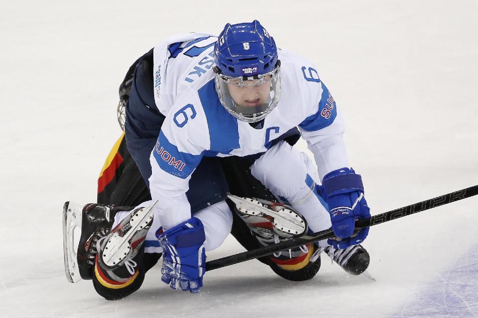 Jenni Hiirikoski of Finland land on top of Maritta Becker of Germany during the 2014 Winter Olympics women's ice hockey game at Shayba Arena, Sunday, Feb. 16, 2014, in Sochi, Russia. Finland defeated Germany 2-1. (AP Photo/Petr David Josek)