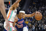 Golden State Warriors guard Jordan Poole, right, is defended by San Antonio Spurs guard Tre Jones during the second half of an NBA basketball game in San Francisco, Saturday, Dec. 4, 2021. (AP Photo/Jeff Chiu)