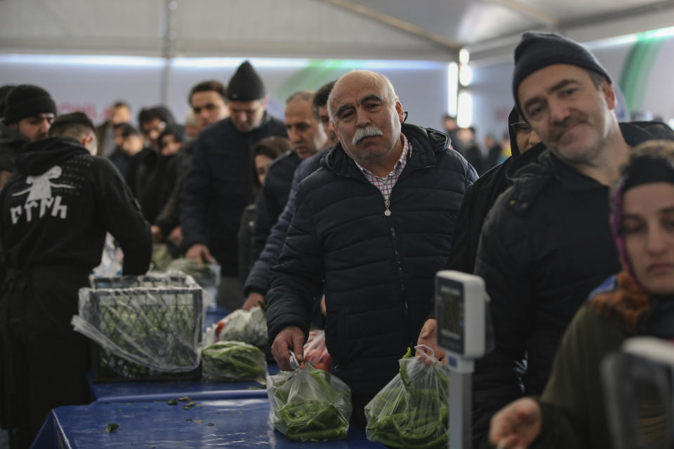 In this Sunday, Feb. 17, 2019 photo, shoppers wait in line to buy groceries at a government-run market selling spinach, tomatoes and peppers at discounted prices in an Istanbul neighbourhood. Turkey's President Recep Tayyip Erdogan's government has set up dozens of these temporary stalls in Turkey's largest cities in a bid to mitigate the effects of soaring food prices that have stung households. The move comes just over a month before Erdogan faces local elections on March 31, when runaway prices and an economic downturn could cost his ruling party some key municipal seats. (AP Photo/Emrah Gurel)