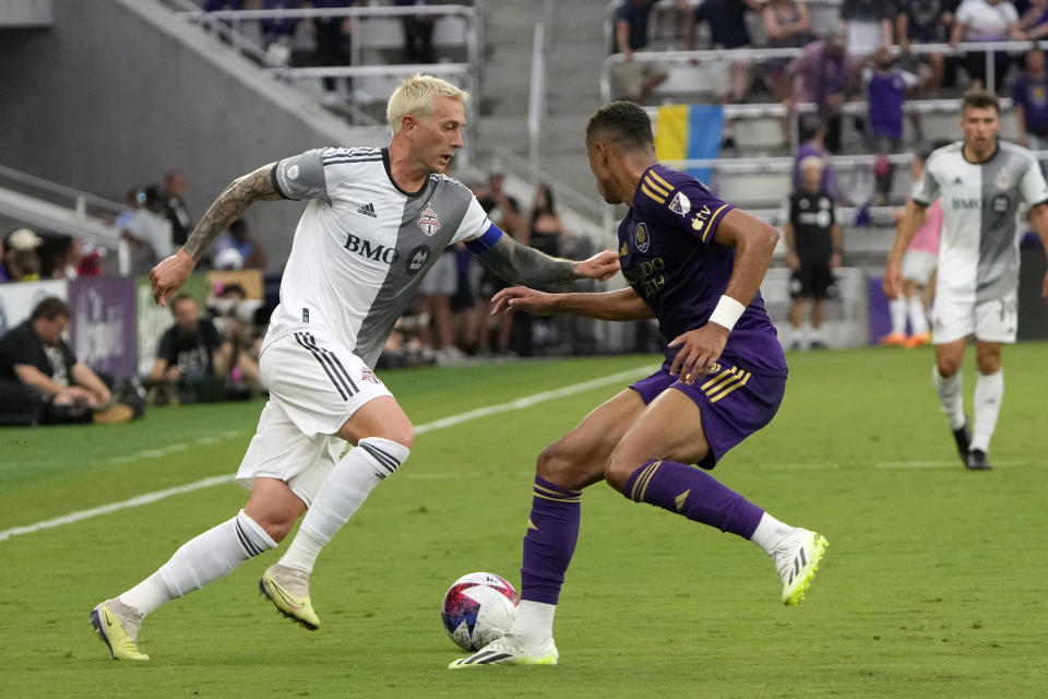 Toronto FC's Federico Bernardeschi, left, moves the ball past Orlando City's Rafael Santos during the first half of an MLS soccer match Tuesday, July 4, 2023, in Orlando, Fla. (AP Photo/John Raoux)