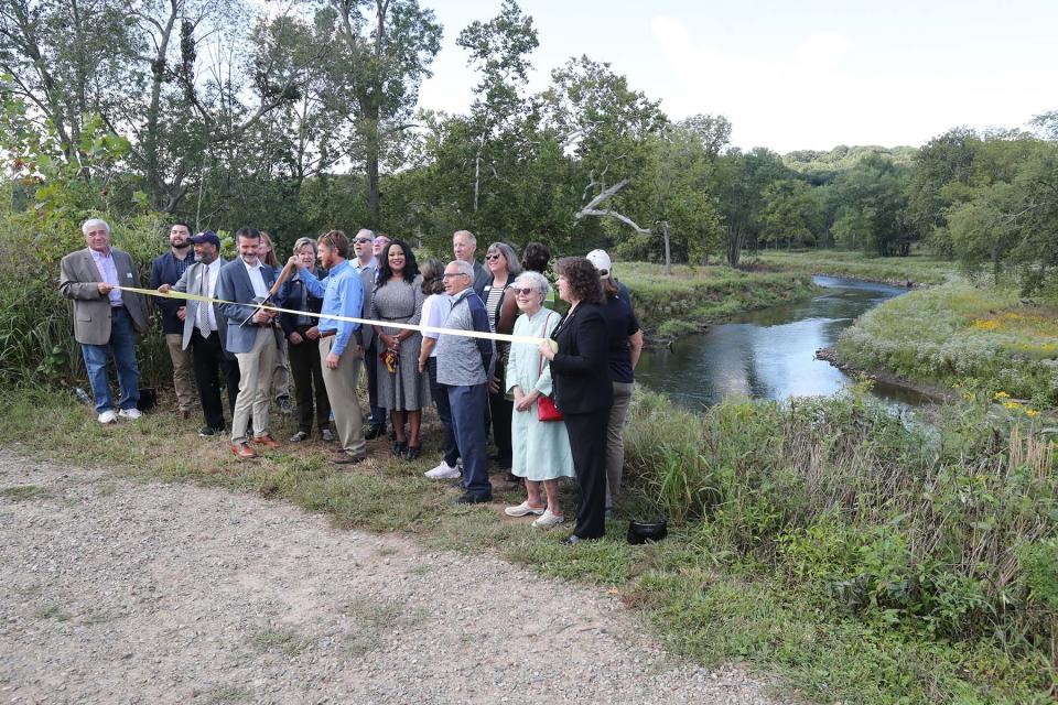 Eric Ellis, left, Great Lakes Commission project manager, and Ryan Darnton, habitat resource specialist with the Great Lakes Regional Office of the NOAA Restoration Center, cut the ribbon Thursday at the Valley View Area of Cascade Valley Metro Park in Akron.