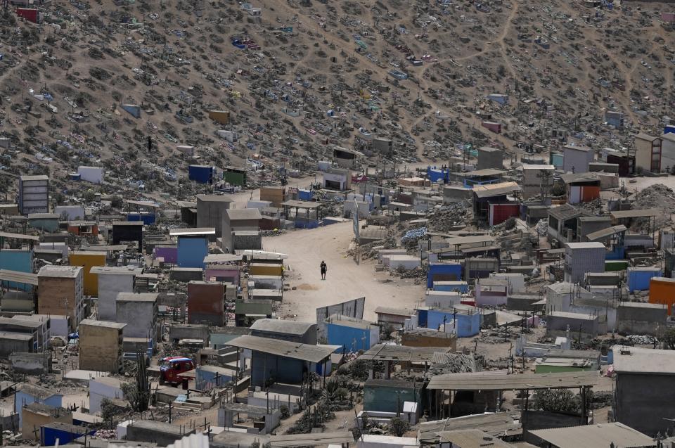 Una persona camina por el cementerio de la Virgen de Lourdes en Lima, Perú, el viernes 9 de diciembre de 2022. (AP Foto/Fernando Vergara)