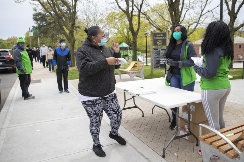 New York City Department of Parks & Recreation staff distribute free face masks at the Mauro playground in the Kew Gardens Hills neighborhood of the Queens borough of New York, Tuesday, May 5, 2020. New York City will distribute 100,000 face coverings in parks across the five boroughs to help protect against the coronavirus.The new coronavirus causes mild or moderate symptoms for most people, but for some, especially older adults and people with existing health problems, it can cause more severe illness or death. (AP Photo/Mary Altaffer)