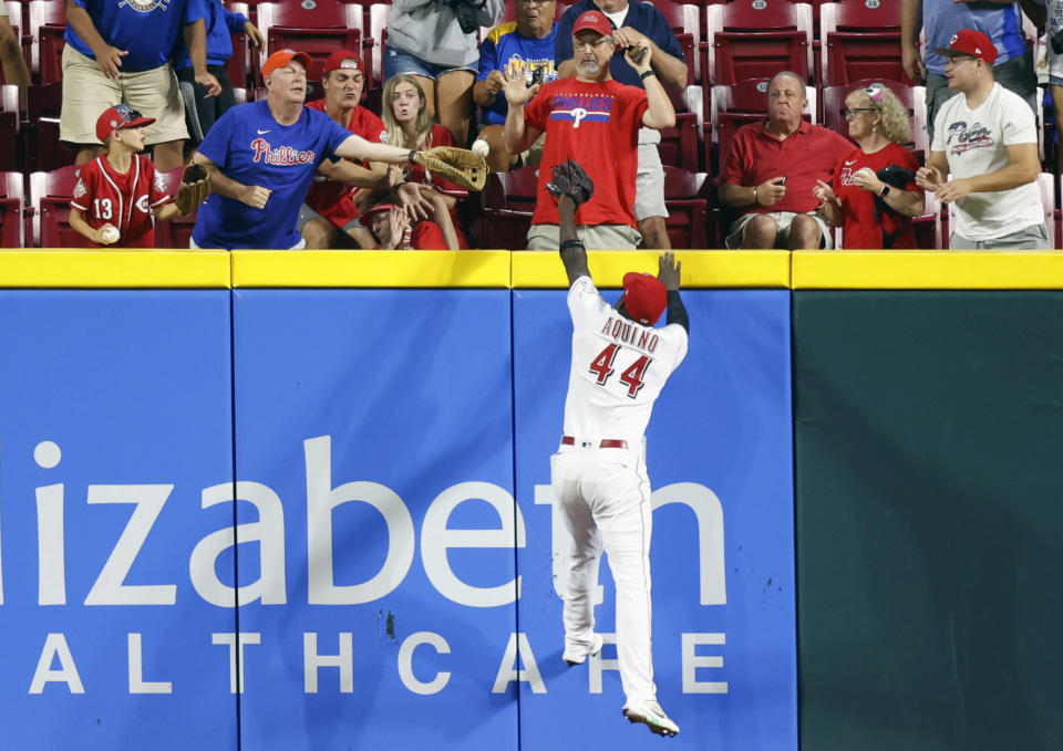 Cincinnati Reds right fielder Aristides Aquino reaches for Philadelphia Phillies' Garrett Stubbs three-run home run during the ninth inning of a baseball game in Cincinnati Tuesday, Aug. 16, 2022. (AP Photo/Paul Vernon)