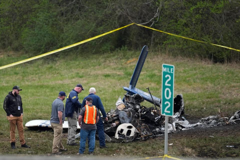 Investigators look over a small plane crash alongside eastbound Interstate 40 at mile marker 202 on Tuesday, March 5, 2024, in Nashville, Tenn.