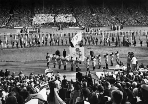 IOC President Sigfried Edström (centre) holds the Olympic flag during the closing ceremony of the 1948 Olympic Games at Wembley Stadium in London. London is the first city to host a third Olympic Games, but the modest Games of the last century were worlds away from today's glossy extravaganzas