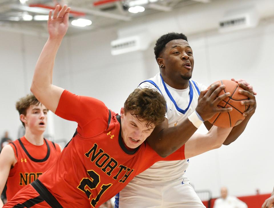 Lincoln Park’s Dorian McGhee comes down with a rebound against North Catholic’s Max Hurray during a PIAA Class 4A quarterfinal game, Friday at Fox Chapel High School.