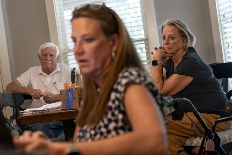 Ralph, left, and Deb Paulsen, the parents of Janet Paulsen, center, look on as she sits in her kitchen in Acworth, Ga., Monday, Aug. 7, 2023. Janet grew up near Chicago and moved to Georgia for college. (AP Photo/David Goldman)