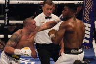 Oleksandr Usyk of Ukraine, left, throws a punch at Anthony Joshua of Britain during their WBA (Super), WBO and IBF boxing title bout at the Tottenham Hotspur Stadium in London, Saturday, Sept. 25, 2021. (AP Photo/Frank Augstein)