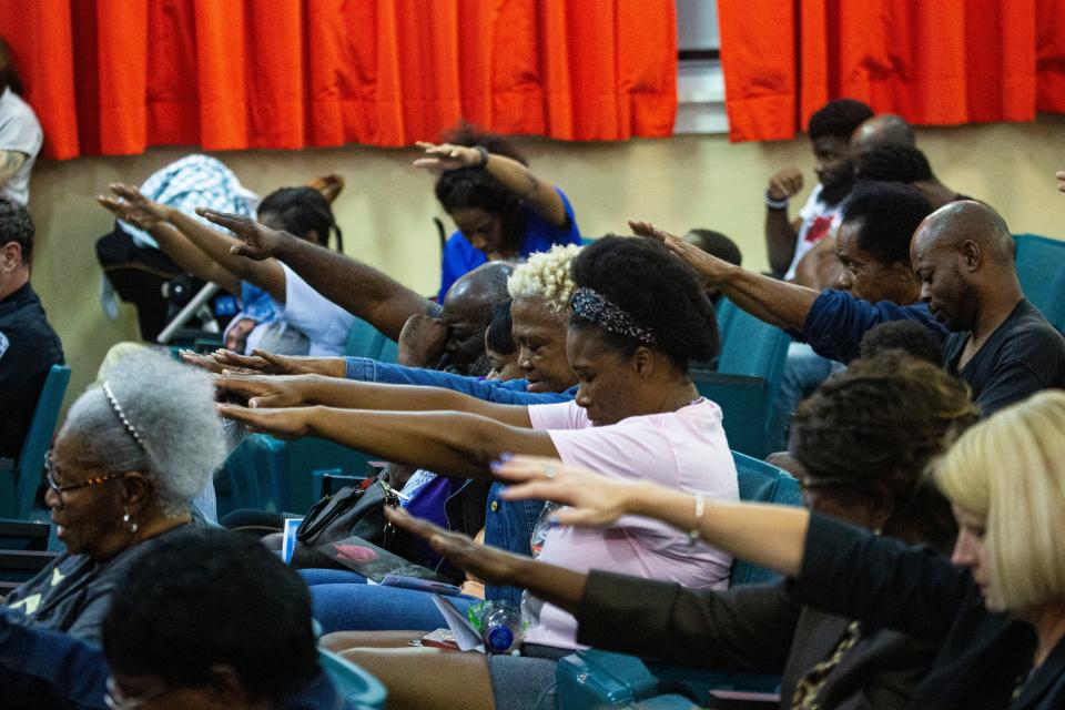 Families pray for youth during the Dunbar Neighborhood Watch & Community Partners 11th annual Community Prayer Service at the Dunbar Community School on Thursday, Feb. 29, 2024. Dozens gathered for the event that featured prayer for community and nation, youth, law enforcement, clergy and bereaved families that have lost someone to a violent crime. The event ended with a candlelight vigil.