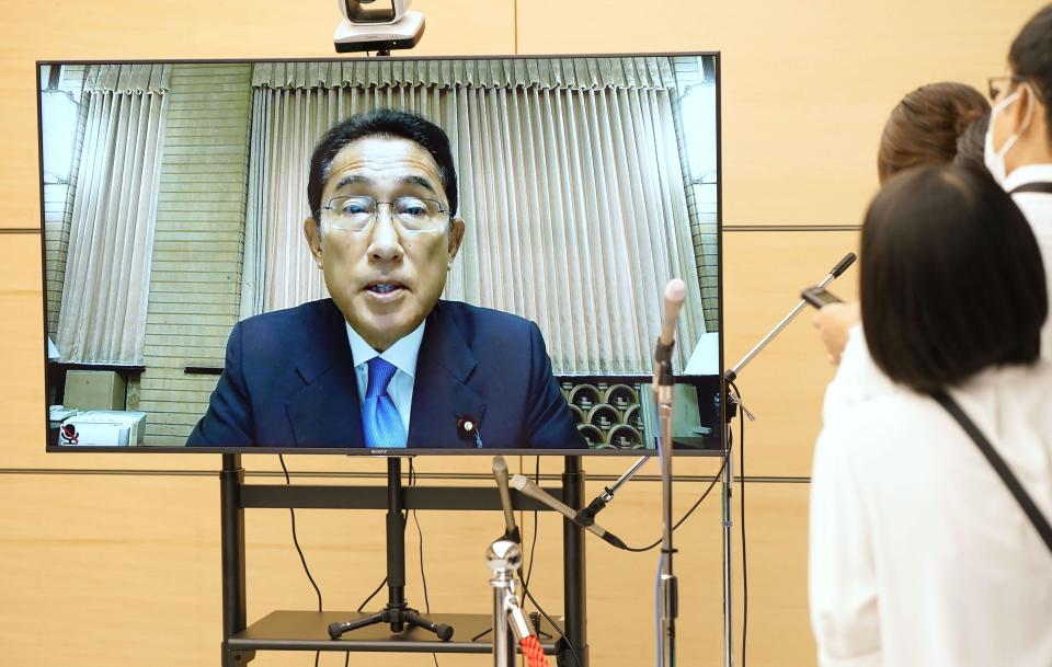 Japanese Prime Minister Fumio Kishida, seen on a screen, speaks to reporters during an online interview at the prime minister's office in Tokyo, Wednesday, Aug. 24, 2022. Kishida on Wednesday announced plans to ease border controls from early September by eliminating requirements for pre-departure COVID-19 tests for travelers who have received at least three vaccine doses, and he will also consider increasing daily entry caps as soon as next month. (Kyodo News via AP)