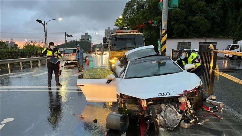 新北市汐止區1部白色超跑因雨路滑失控自撞電線杆，車體幾乎全毀。（圖／翻攝畫面）