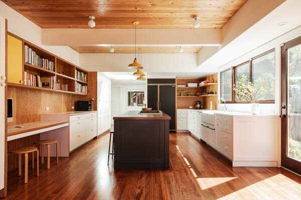 Exposed beams stretch across the main level, connecting the living areas and kitchen.