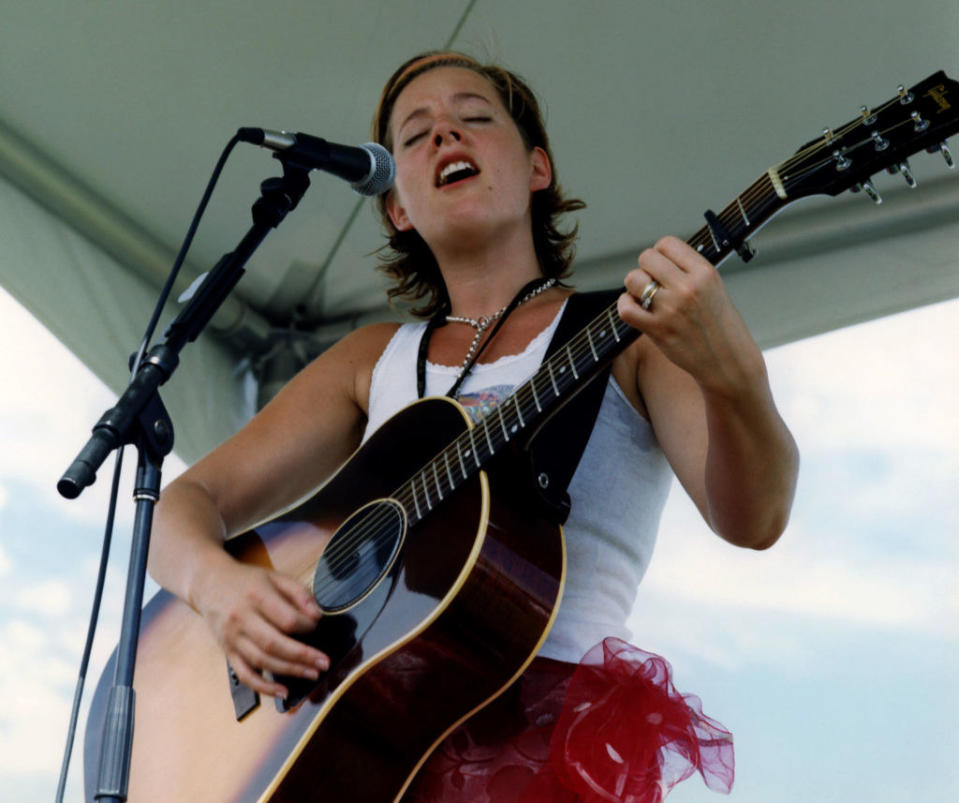 Sarah playing guitar and singing on stage