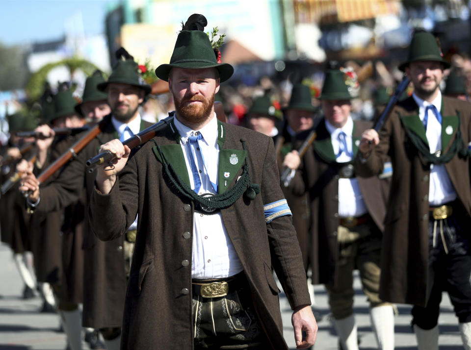 Men in traditional costumes carry rifles as they take part in a parade as part of the opening of the 186th 'Oktoberfest' beer festival in Munich, Germany, Saturday, Sept. 21, 2019. (AP Photo/Matthias Schrader)