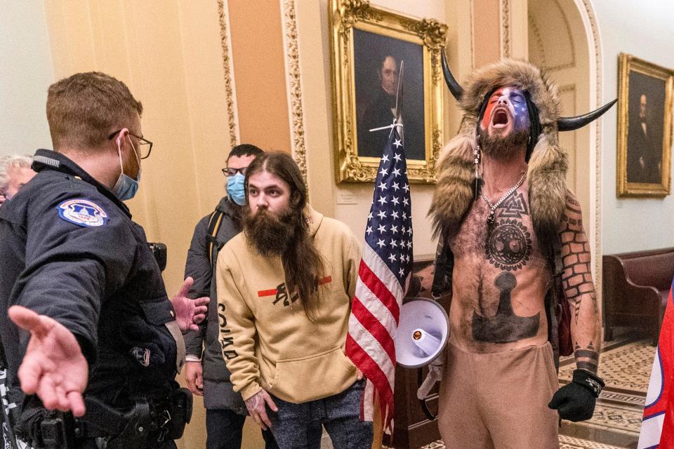 FILE - In this Wednesday, Jan. 6, 2021 file photo, supporters of President Donald Trump, including Jacob Chansley, right with fur hat, are confronted by U.S. Capitol Police officers outside the Senate Chamber inside the Capitol in Washington. Chansley made a written apology from jail, asking for understanding as he was coming to grips with his actions. (AP Photo/Manuel Balce Ceneta, File)