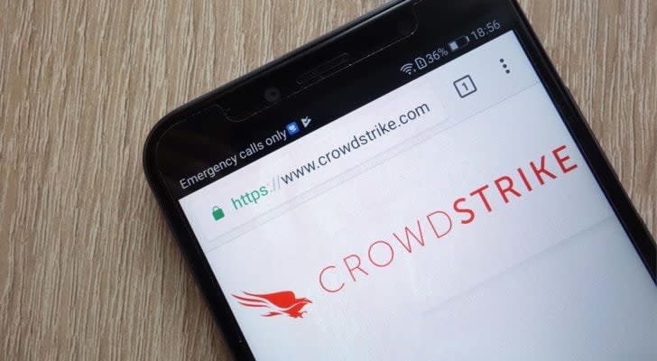 Image of Crowdstrike (CRWD) logo on a mobile phone lying on a wooden table