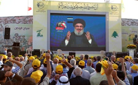 Lebanon's Hezbollah leader Sayyed Hassan Nasrallah gestures as he addresses his supporters via a screen during a rally marking the anniversary of the defeat of militants near the Lebanese-Syrian border, in al-Ain village