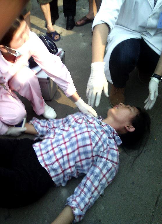 An employee of Lide shoe factory lies on the ground after what workers said were clashes with police, during a strike against their employers, in Panyu, south China's Guangdong province