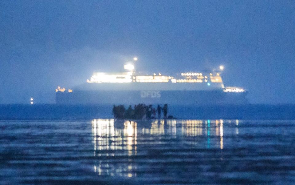 Migrants including families embark on the beach of Gravelines as a ferry of the Danish shipping company DFDS sails in the Channel (Manche), near Dunkirk, northern France on September 22, 2020 - SAMEER AL-DOUMY/AFP