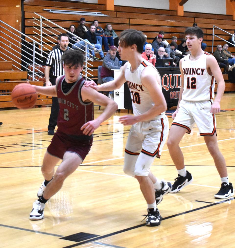 Union City's Nathaniel Maurer (2) drives baseline while Quincy's Clayton Benson (10) defends