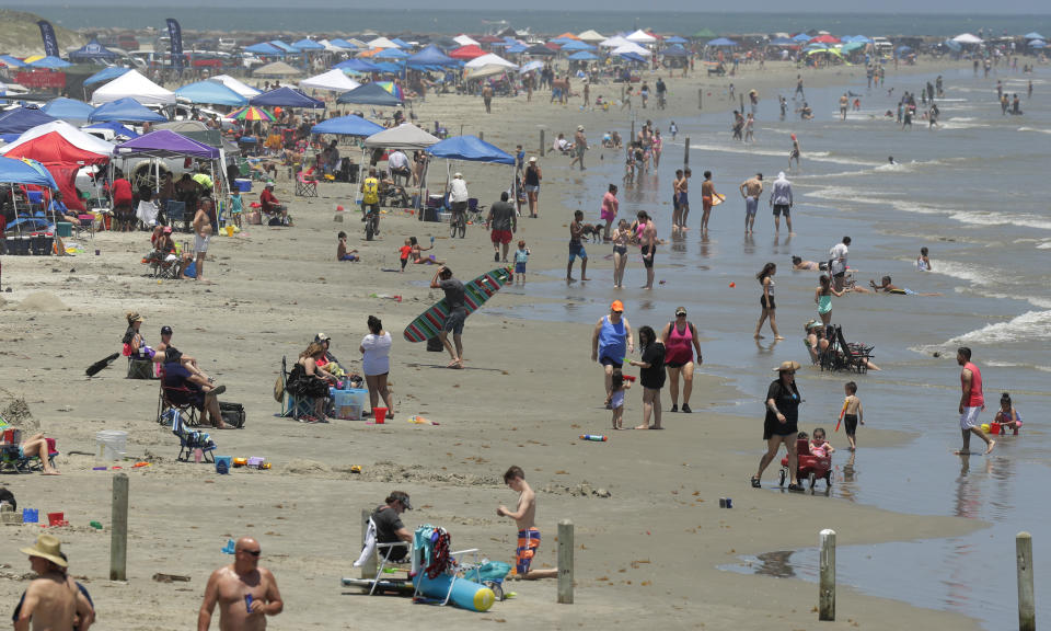 FILE- In this May 23, 2020, file photo people gather on the beach for the Memorial Day weekend in Port Aransas, Texas, Saturday, May 23, 2020. Beachgoers are being urged to practice social distancing to guard against COVID-19. President Donald Trump says that the country is anxious to get back to work and that pent-up consumer demand can turn things around quickly. Presumptive Democratic nominee Joe Biden counters by urging caution and heeding medical and scientific experts. (AP Photo/Eric Gay, File)