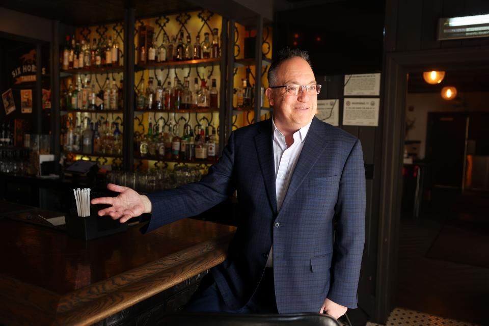 Franz Bauer, co-owner and general manager of the Aurora Inn, shows off the bar of the Six Horses Tavern.