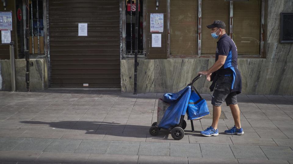 Ein Lieferant geht vor einer Bar im spanischen Peralta vorbei, die geschlossen ist, um die Verbreitung des Coronavirus zu verhindern.