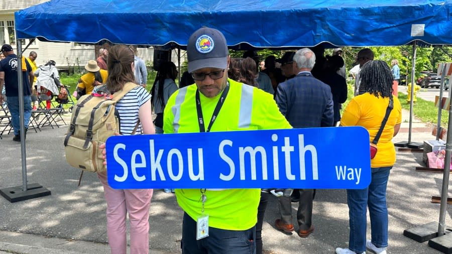 Alfonso Payne, a high school classmate of Sekou Smith, installs a road sign in his late friend's honor. (May 15, 2024)