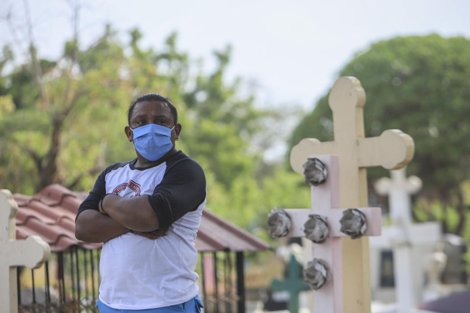 A person wears a mask as he attends a funeral at the Central cemetery of Managua, Nicaragua, Monday, May 11, 2020. President Daniel Ortega's government has stood out for its refusal to impose measures to halt the new coronavirus for more than two months since the disease was first diagnosed in Nicaragua. Now, doctors and family members of apparent victims say, the government has gone from denying the disease's presence in the country to actively trying to conceal its spread. (AP Photo/Alfredo Zuniga)