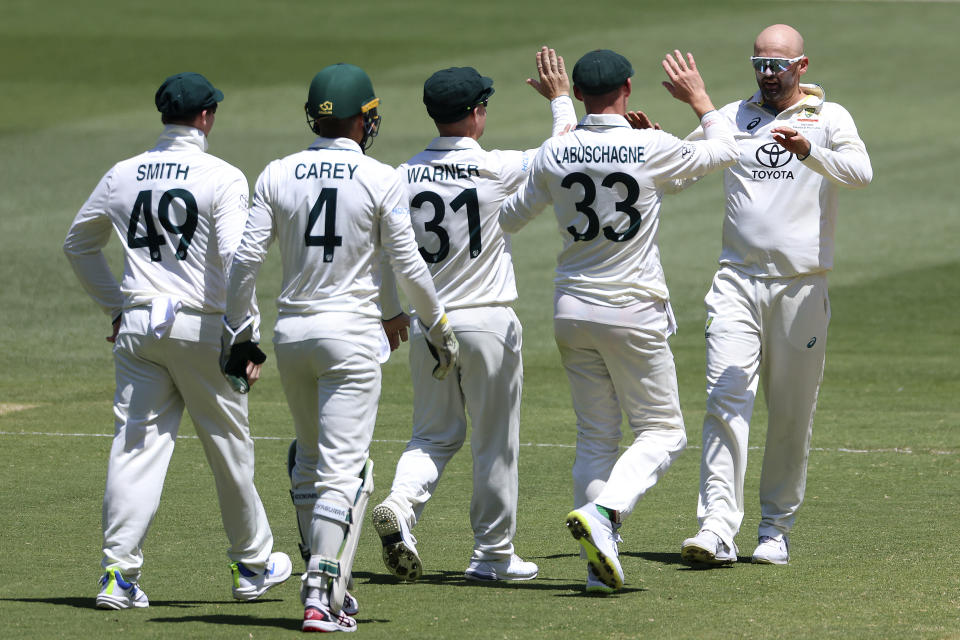 Australia's Nathan Lyon, right, is congratulated by teammates after taking the wicket of Pakistan's Imam-ul-Haq during the second day of their cricket test match in Melbourne, Wednesday, Dec. 27, 2023. (AP Photo/Asanka Brendon Ratnayake)