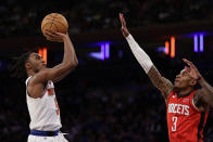 New York Knicks guard Immanuel Quickley, left, looks to shoot over Houston Rockets guard Kevin Porter Jr. (3) during the second half of an NBA basketball game Monday, March 27, 2023, in New York. (AP Photo/Adam Hunger)