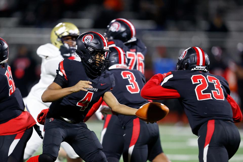 Aliquippa quarterback Quentin Goode hands off to running back Tiqwai Hayes in the first half against Bishop McDevitt.