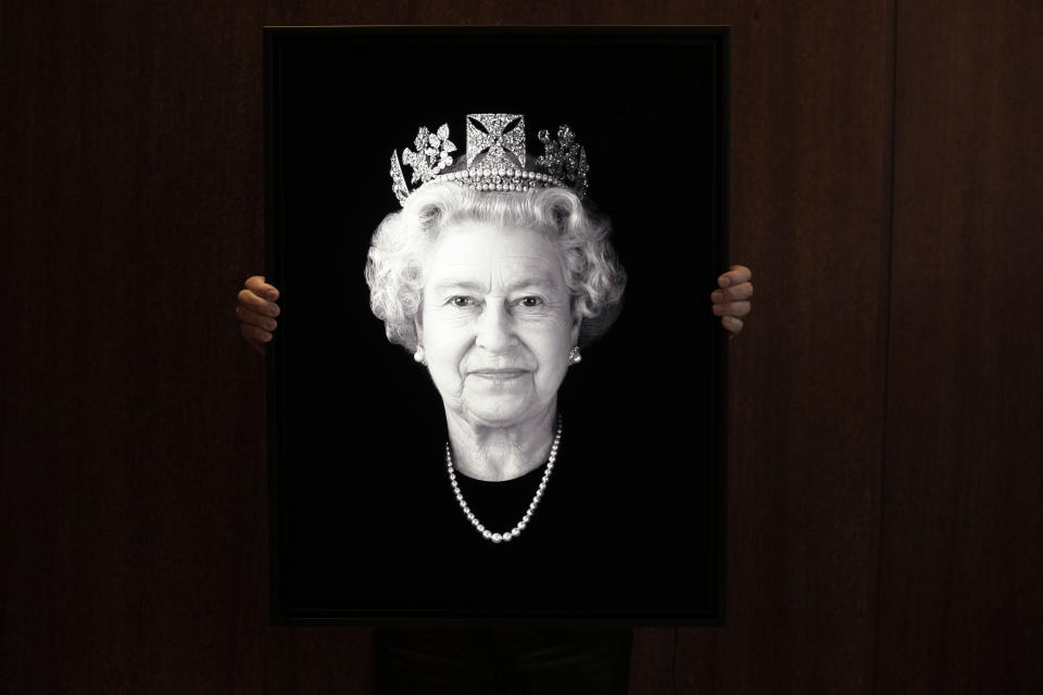 FILE - Rob Munday, creator of the first officially commissioned 3D/holographic portrait of Britain's Queen Elizabeth II in 2004, unveils a previously unseen portrait of the monarch to celebrate the Platinum Jubilee, in London, Wednesday, May 4, 2022. Britain is getting ready for a party featuring mounted troops, solemn prayers — and a pack of dancing mechanical corgis. The nation will celebrate Queen Elizabeth II’s 70 years on the throne this week with four days of pomp and pageantry in central London. (AP Photo/Kirsty Wigglesworth, File)