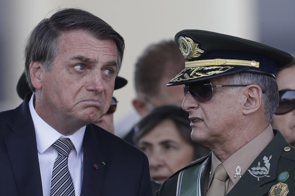 Brazils President Jair Bolsonaro, left, talks with Army Commander General Edson Leal Pujol, during a military ceremony for the Day of the Soldier, at Army Headquarters in Brasilia, Brazil, Friday, Aug. 23, 2019. Brazilian President Jair Bolsonaro says he's leaning toward sending the army to help fight Amazon fires that have alarmed people across the globe. (AP Photo/Eraldo Peres)