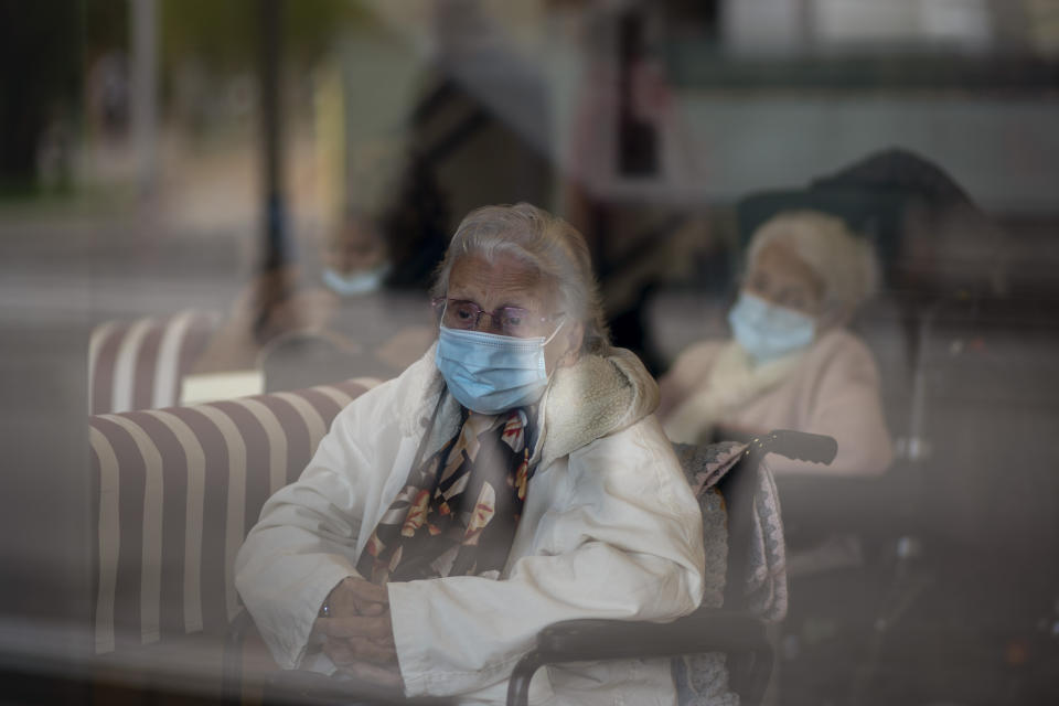 Residents look at the street through a window at the Icaria nursing home in Barcelona, Spain, Wednesday, Nov. 25, 2020. Virus cases among the elderly are again on the rise across Europe, causing havoc and rising death tolls in nursing homes despite the lessons of a tragic spring. Authorities are in a race to save lives as they wait for crucial announcements on mass vaccinations. (AP Photo/Emilio Morenatti)
