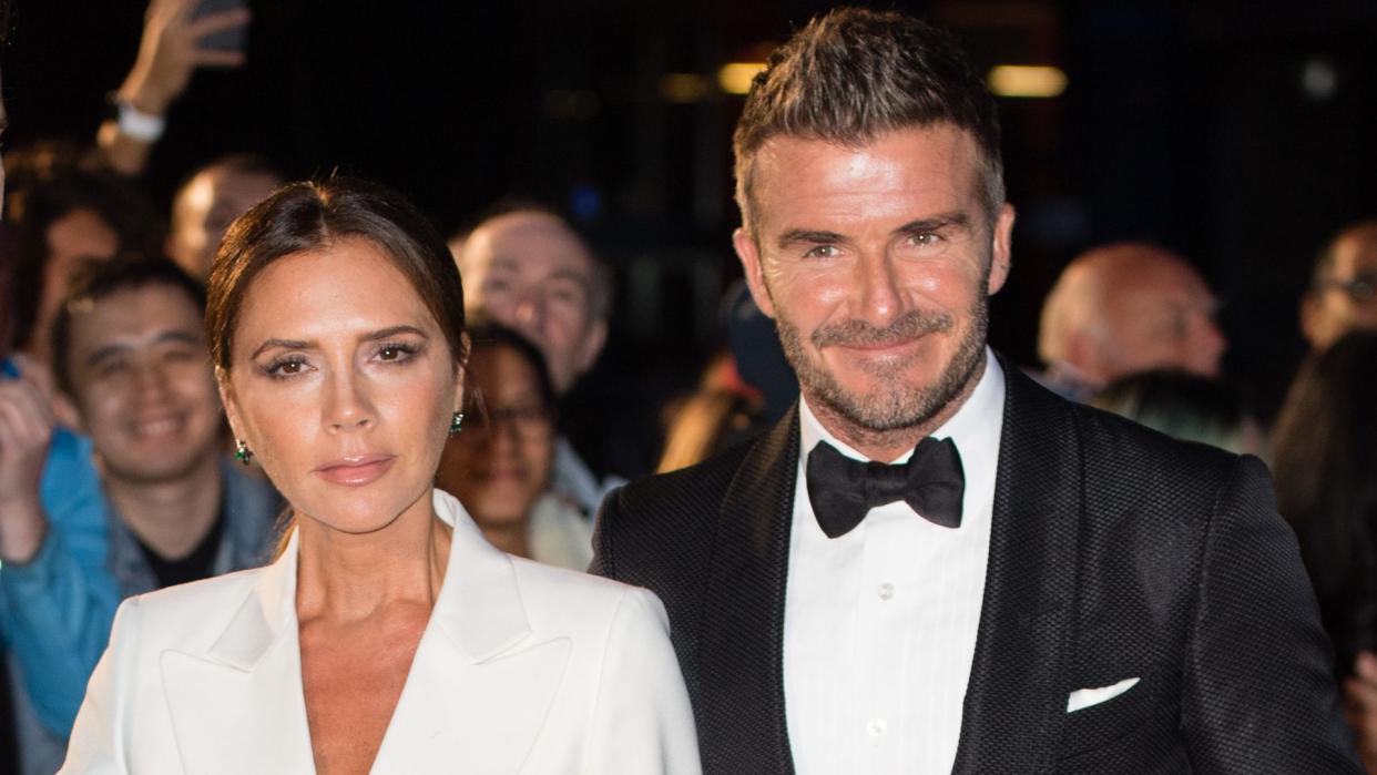 Victoria Beckham in white and David Beckham in a tuxedo