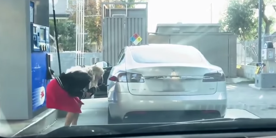 <p>Footage shows the driver looking puzzled as she searches for the car’s filler cap</p>